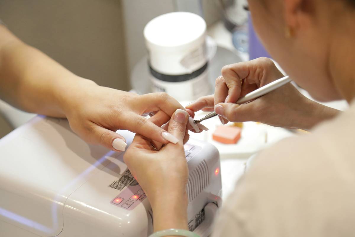 Close-up of clean, hydrated fingernails beside a cotton pad soaked in nail prep solution